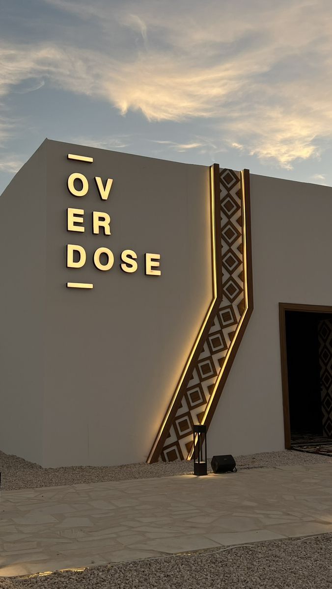 Фасадна світлова вивіска OVERDOSE з вертикальним розміщенням — стильні обʼємні літери з підсвіткою, виконані YBA.